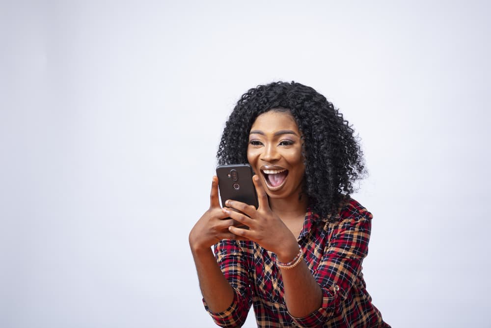Woman delighted by a text message on her phone