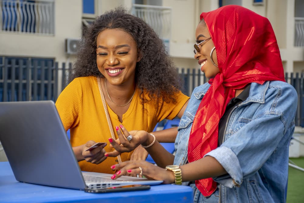 Two colleagues replying to customers from a laptop